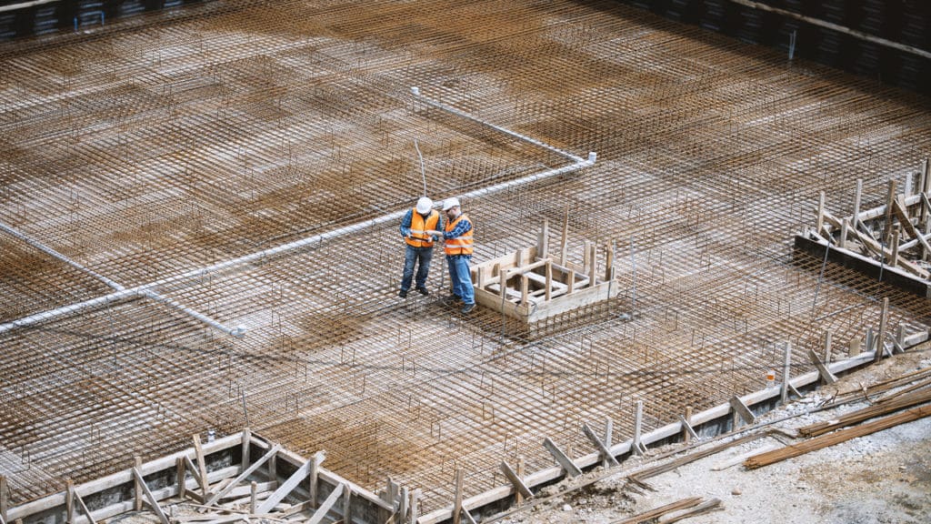 Dois homens conversando em um ambiente de obras.