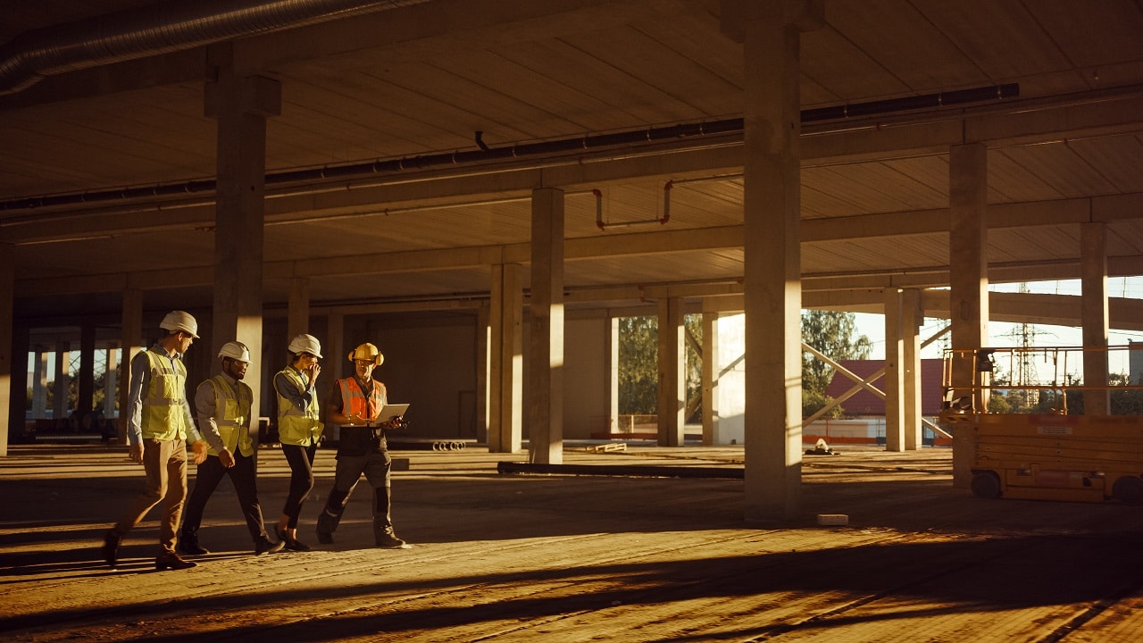trabalhadores andando no esqueleto de um prédio em construção